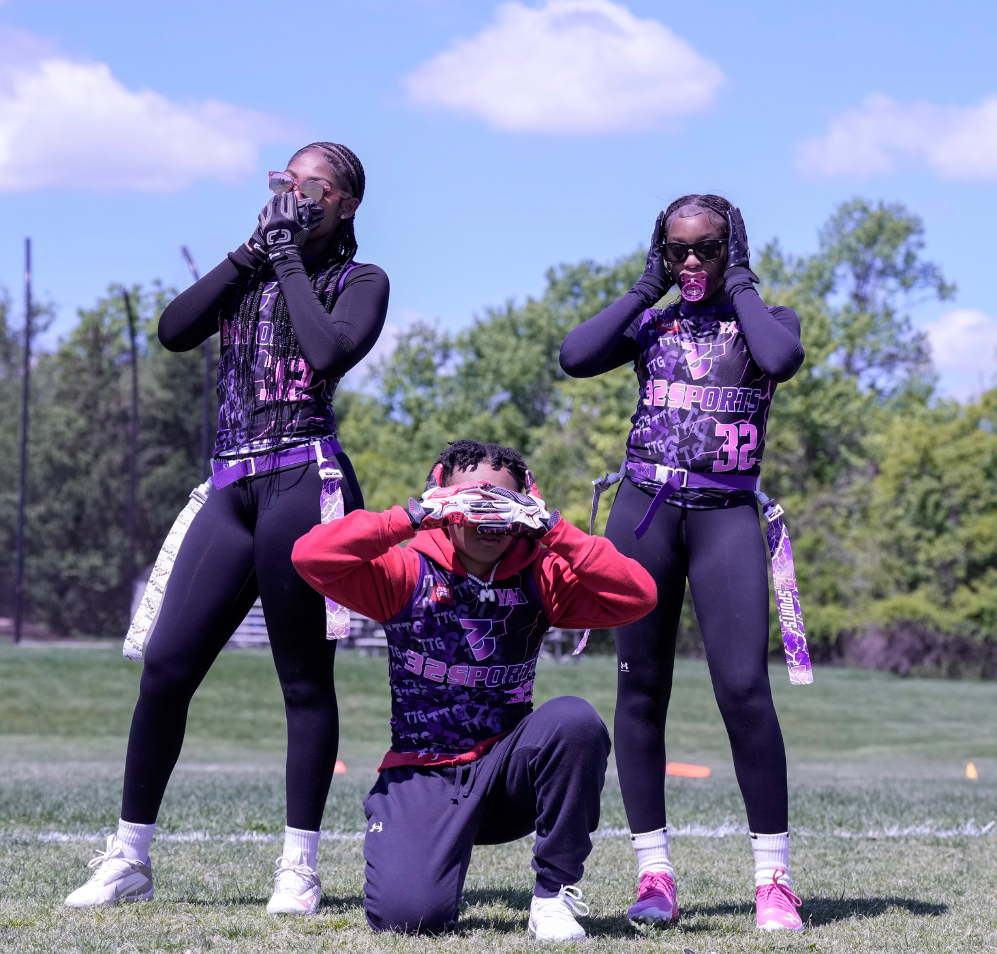 Three 32 Sports teammates posing together on the field