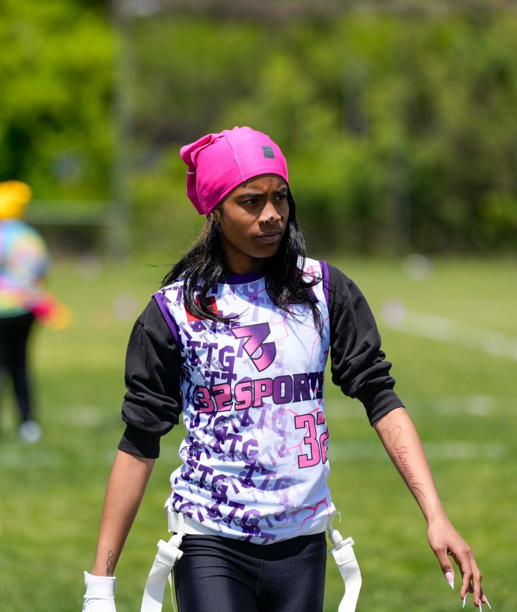 32 Sports athlete in a pink headwrap focused on the field