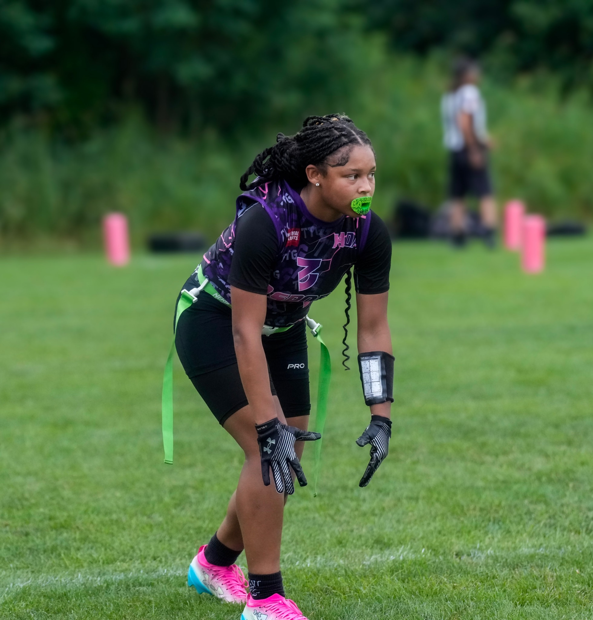 32 Sports athlete in a defensive stance with green flags and pink cleats