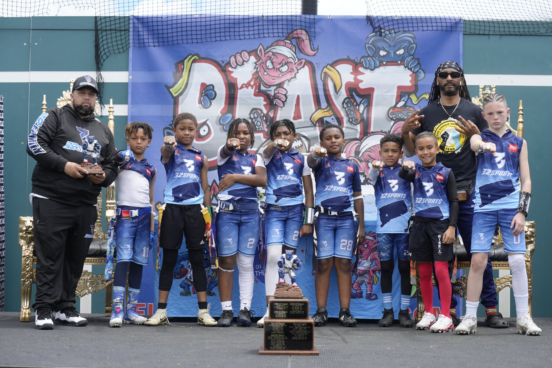 32 Sports youth team celebrating with trophies and championship rings